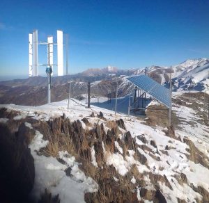 Vertical Axis Wind Turbine (VAWT) mounted on top of a snowcapped mountain range.